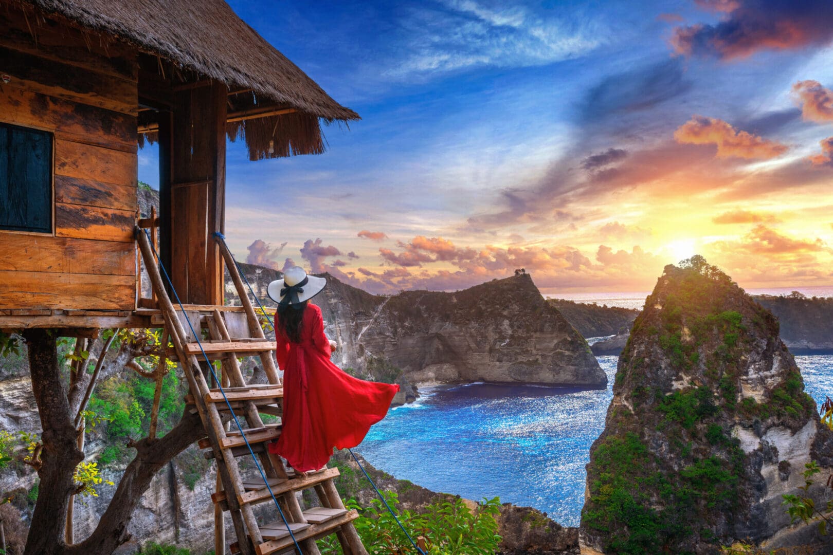 Young girl on steps of house on tree at Atuh beach in Nusa Penida island, Bali in Indonesia.